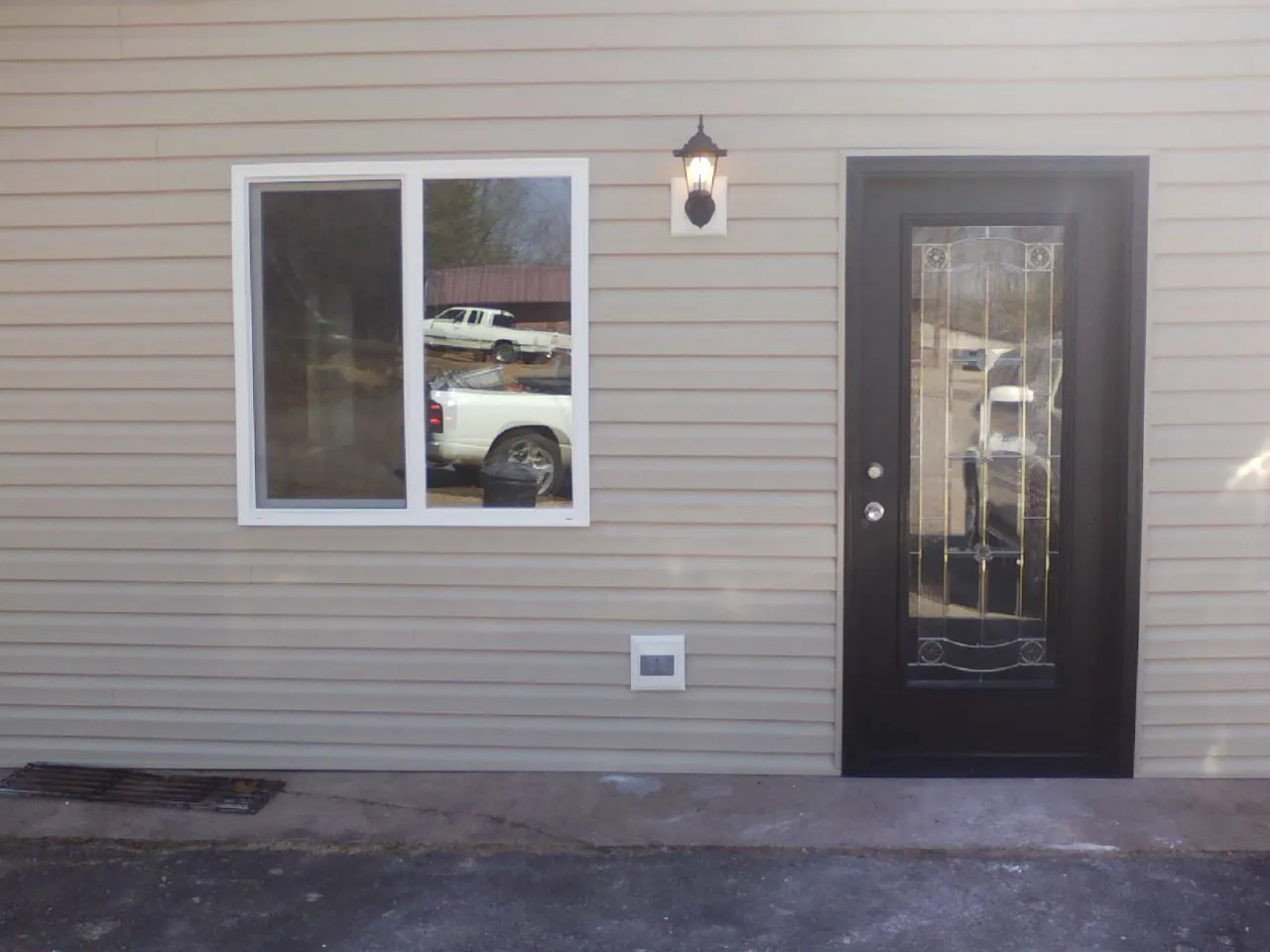 New siding, window and entry door on the side of an addition in Imperial