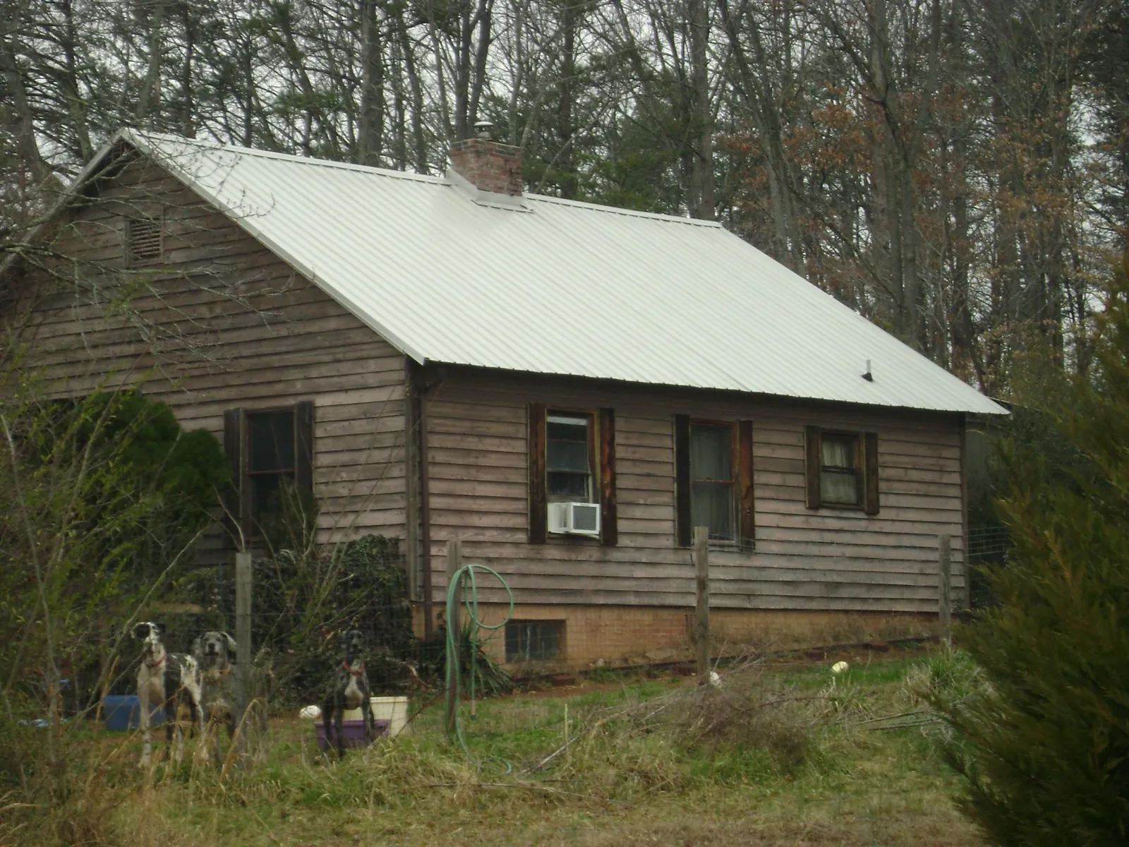 White metal roof on an old wood sided farmhouse, from a Metal Roof Installation job in Imperial
